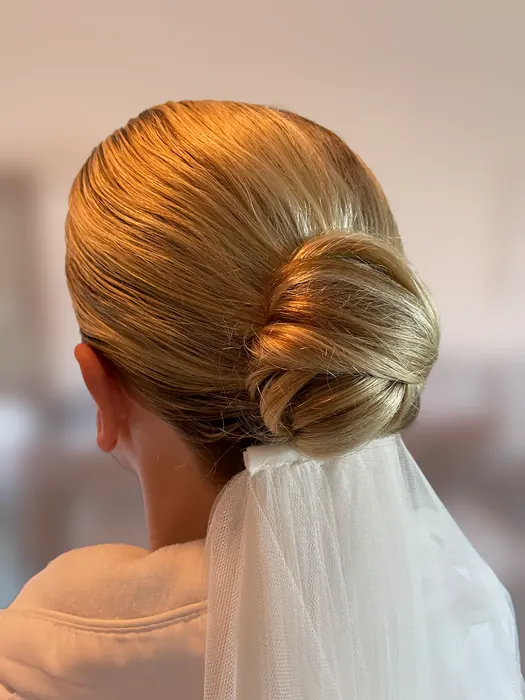 Sleek blonde bridal chignon with veil
